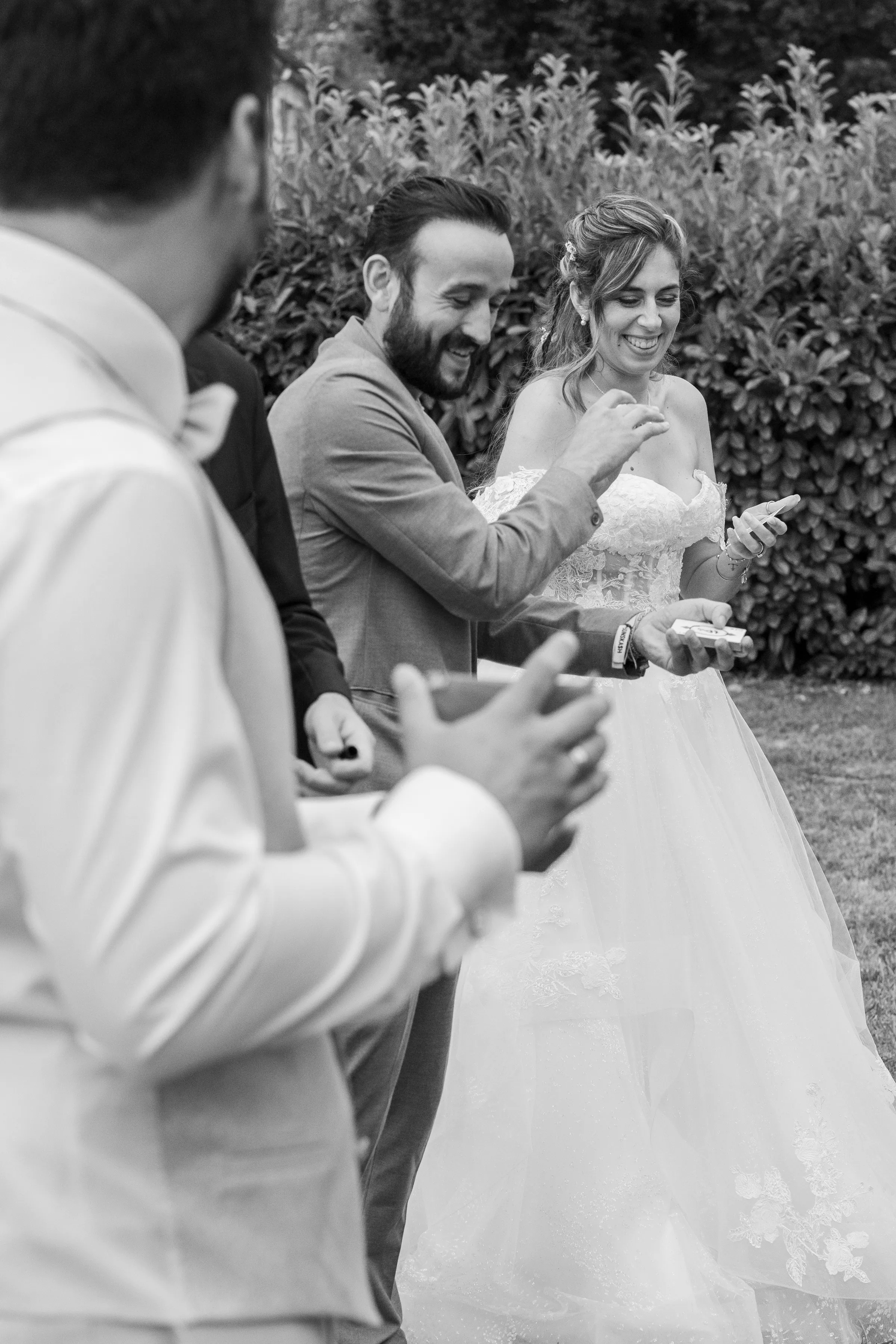 Tyson Dumas, magicien, fait rire la mariée avec un tour de cartes pendant un mariage en plein air